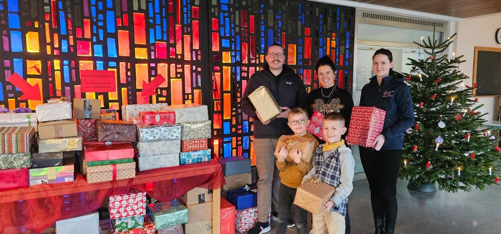 Kinder, Lehrer und Vertreter des DRK neben einem Tisch voller Geschenke