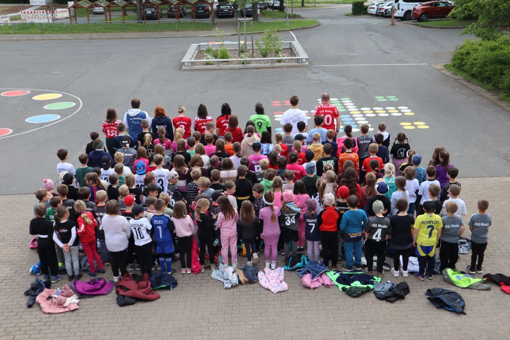 Schulgemeinschaft in Trikots und Trainingsanzügen