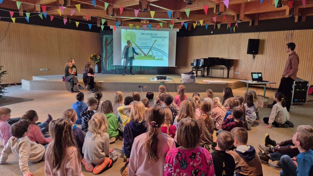 Kinder hören einem Vortrag zum Klimaschutz zu
